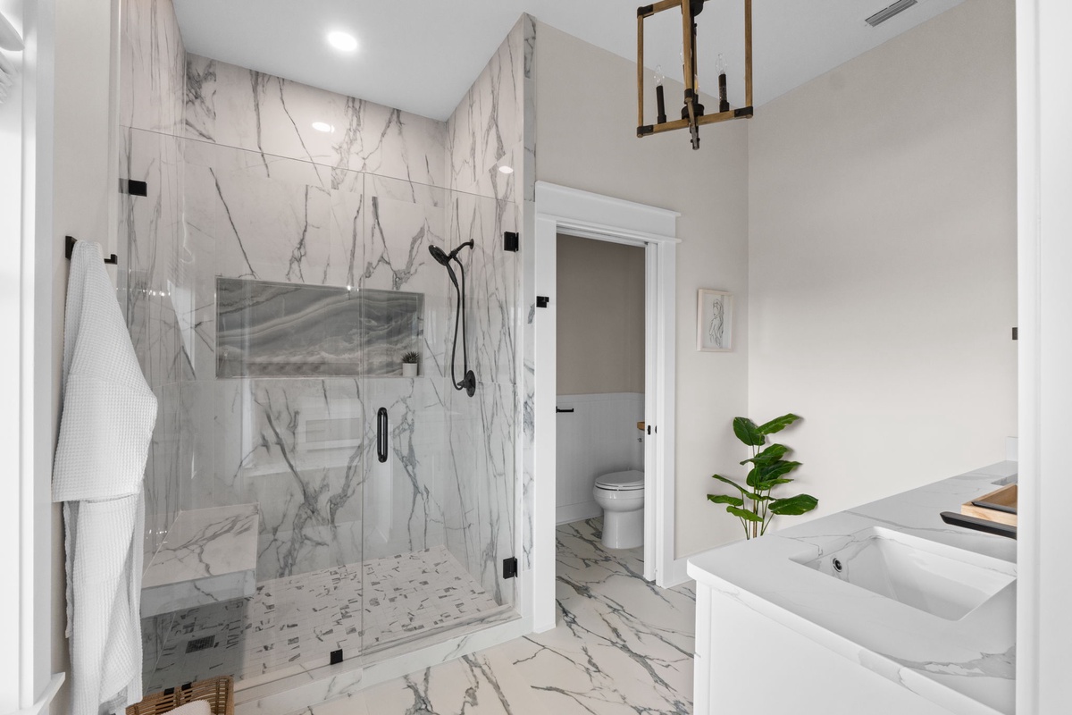 Luxurious marble bathroom with spacious walk-in shower, elegant fixtures, and sophisticated design—your private spa retreat awaits.