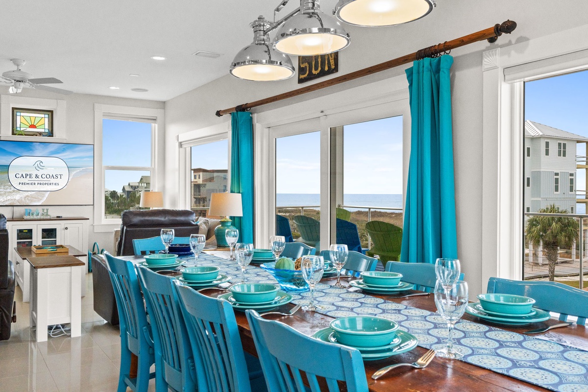 Your dining space features coastal-inspired turquoise accents and stunning ocean views through floor-to-ceiling windows, perfect for memorable meals.