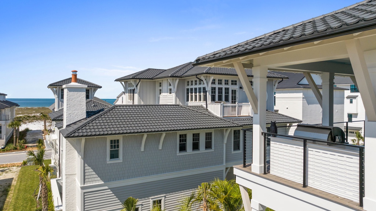 Coastal architecture meets elegant design in this beachside property featuring covered outdoor spaces and ocean views. The exterior showcases classic styling with modern touches in a prime waterfront location.