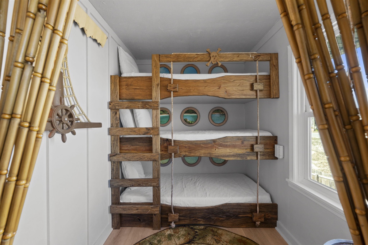 A one-of-a-kind custom bunk room features nautical-inspired wood bunks, playful details, and a layout designed for fun and functionality.