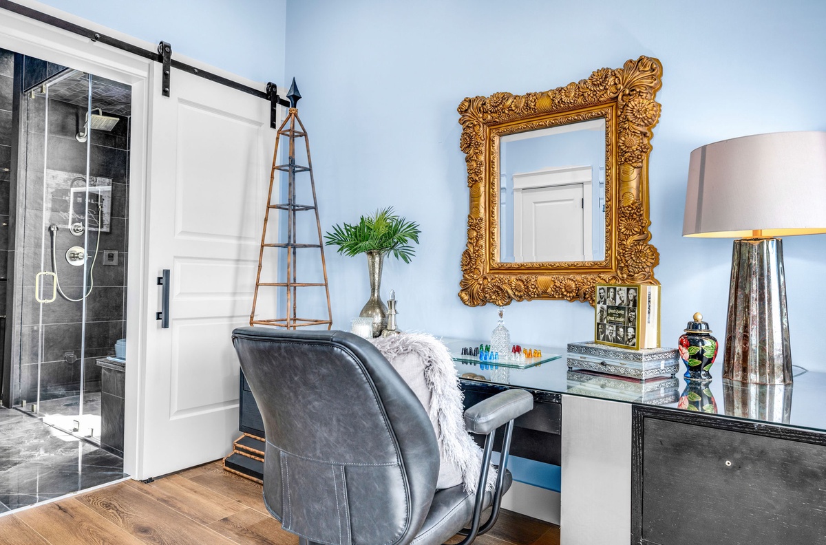 Your elegant vanity space blends classic charm with modern comfort, featuring a golden ornate mirror and luxurious seating.