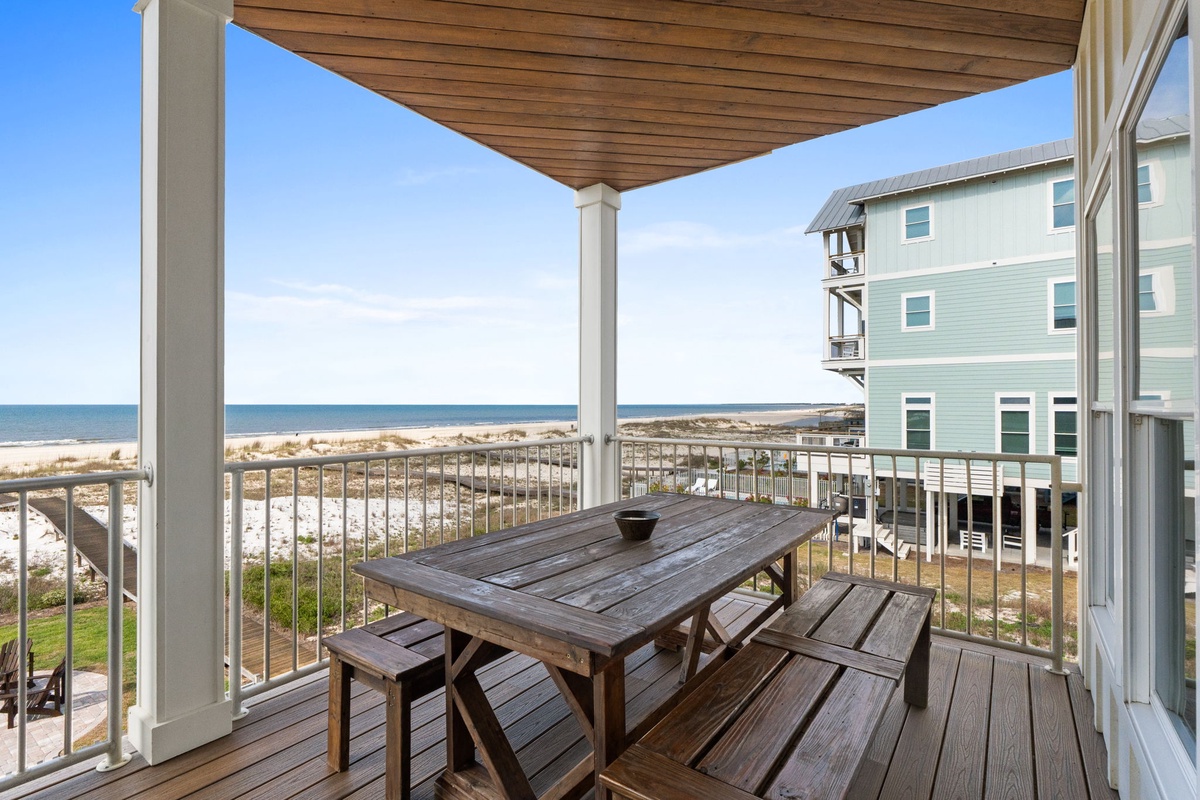 This covered balcony offers stunning beachfront views where azure waters meet sandy shores. The property sits on a quiet coastal street, providing a peaceful retreat near the sea.