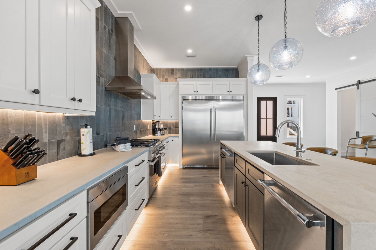 Your gourmet kitchen awaits with sleek countertops, professional appliances, and warm pendant lighting perfect for culinary adventures.