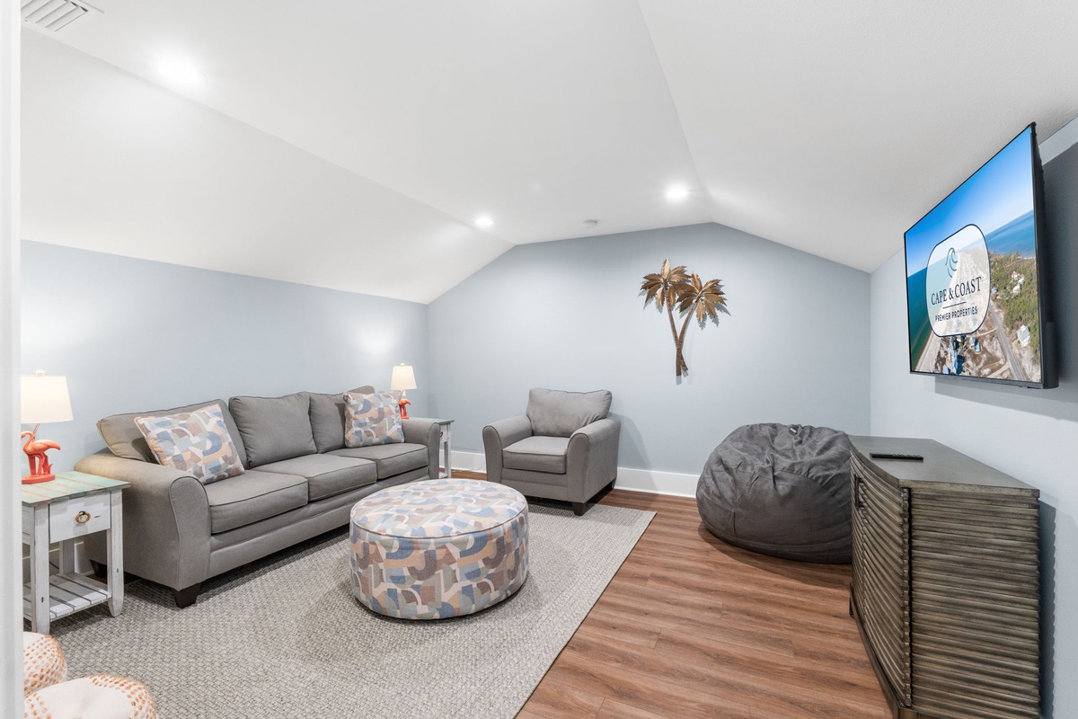 Unwind in your inviting living space with soft seating, coastal decor, and a wall-mounted TV perfect for movie nights and family game time.