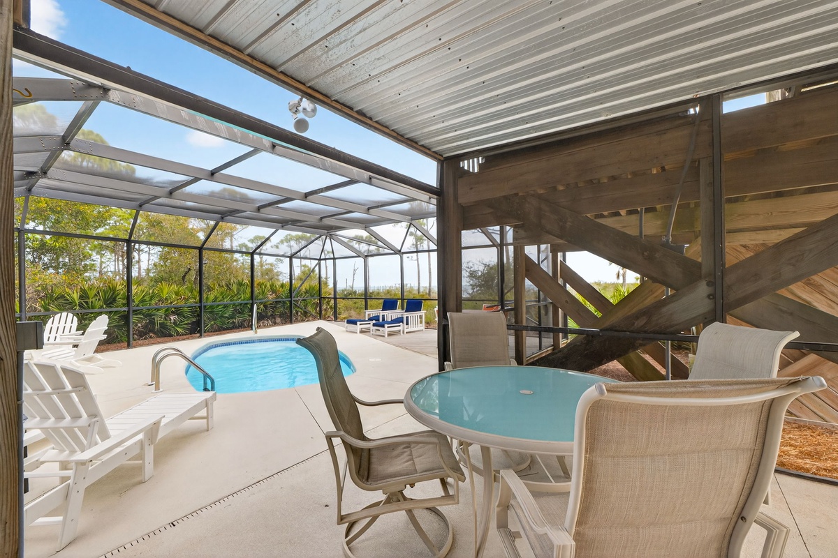 Dive into your private oasis where the screened pool sparkles beneath soaring wooden beams and Florida sunshine streams through glass walls.