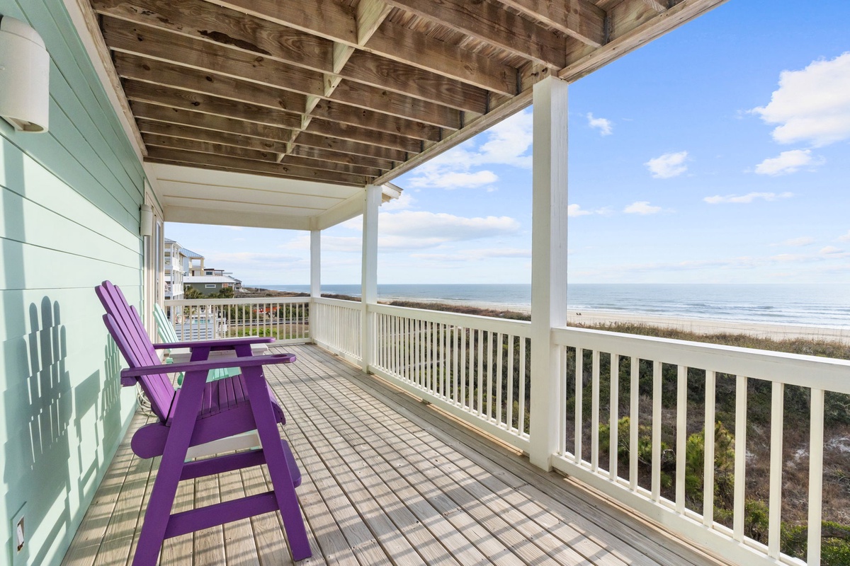 Settle into your private oceanfront deck with purple Adirondack chairs and breathtaking sea views stretching to the horizon.