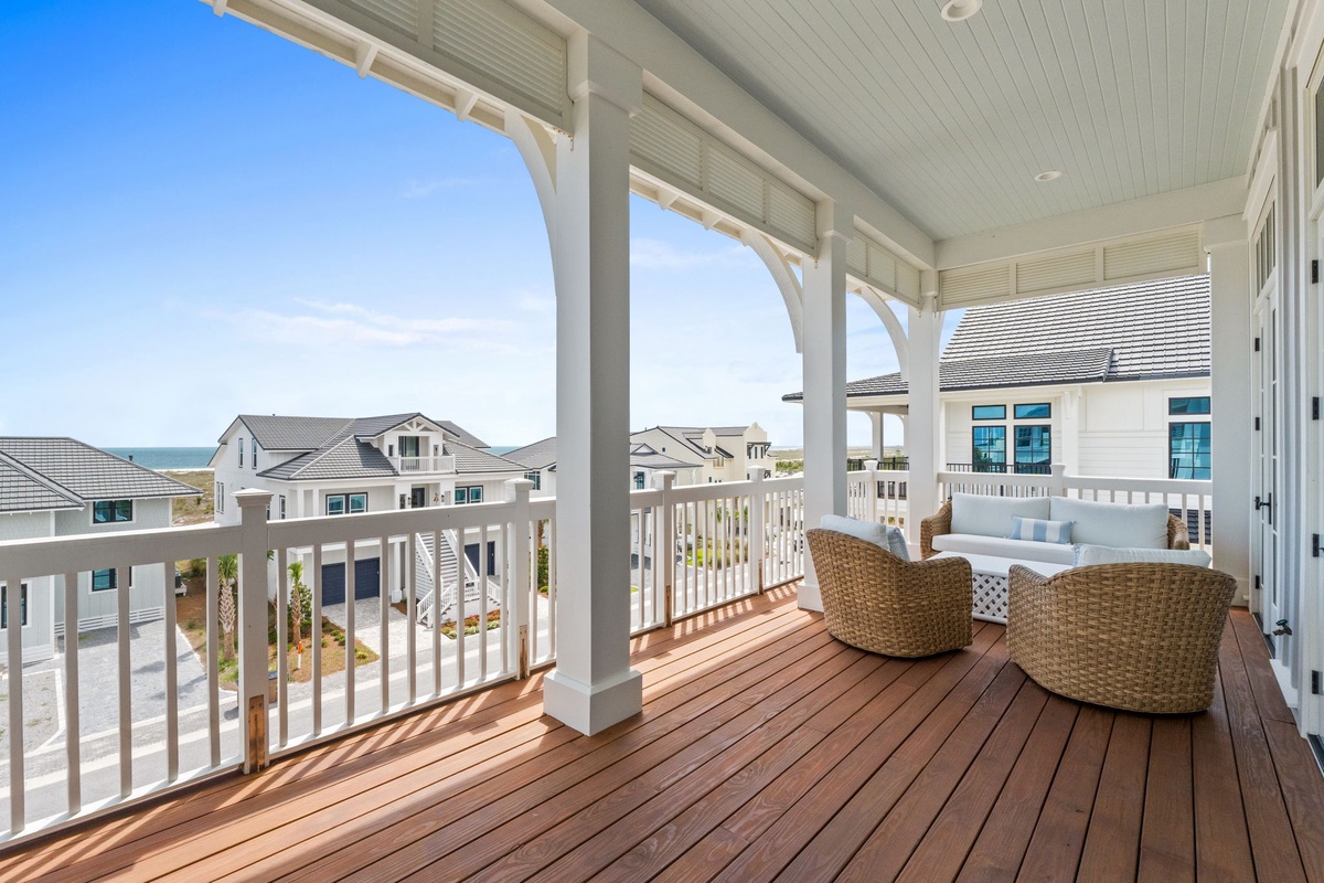Relax in your cozy wicker chairs on this covered balcony, where ocean breezes and coastal views create the perfect morning coffee or sunset escape.