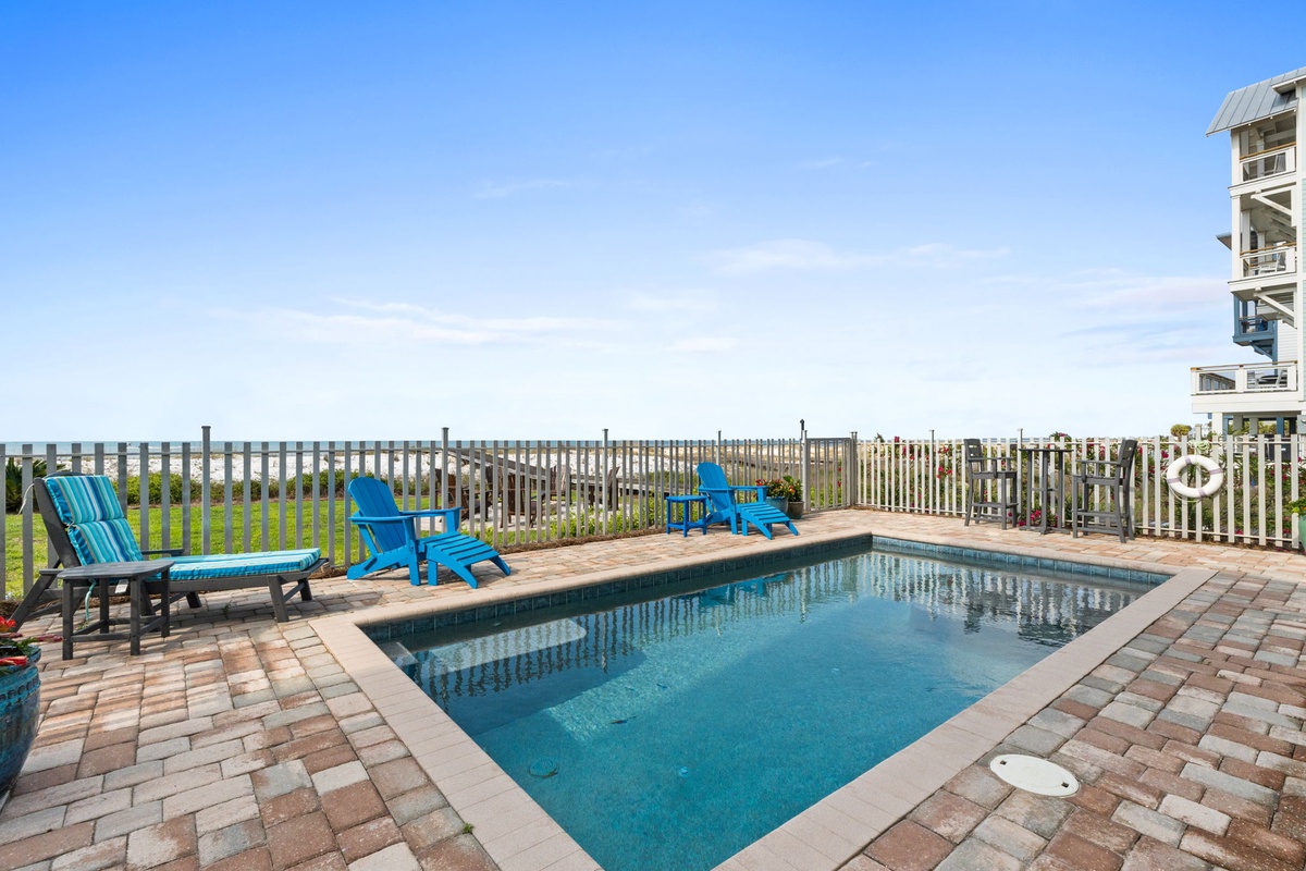 A beachside retreat featuring a private pool and coastal views, surrounded by natural dunes and beach access just steps away from the property.