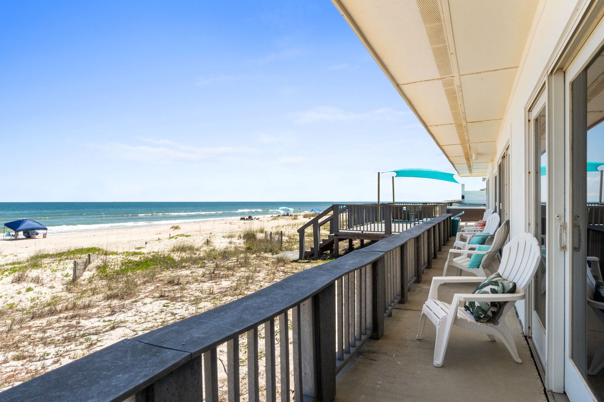 Unwind on your private beachfront balcony with stunning sea views, white sand just steps away, and comfortable seating perfect for morning coffee or sunset relaxation.