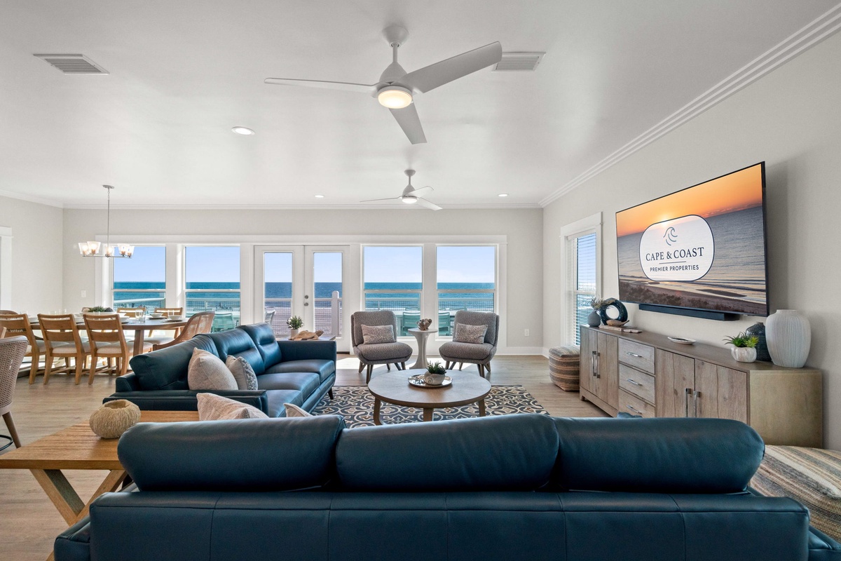 Your spacious living room flows seamlessly into the dining area, where stunning ocean views stretch beyond floor-to-ceiling windows.