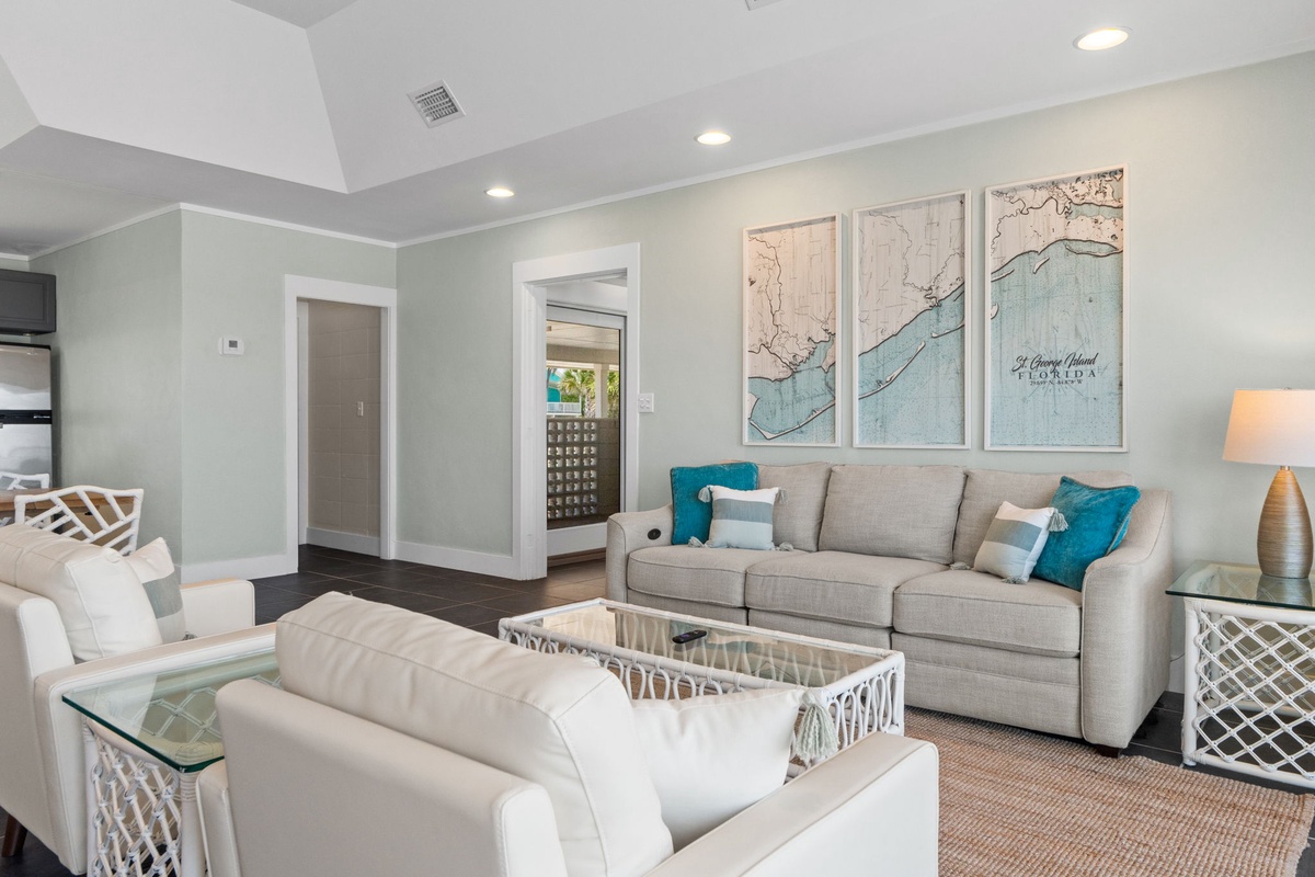 Settle into this inviting coastal-inspired living room with plush seating, teal accents, and charming local map art that adds personality to your stay.