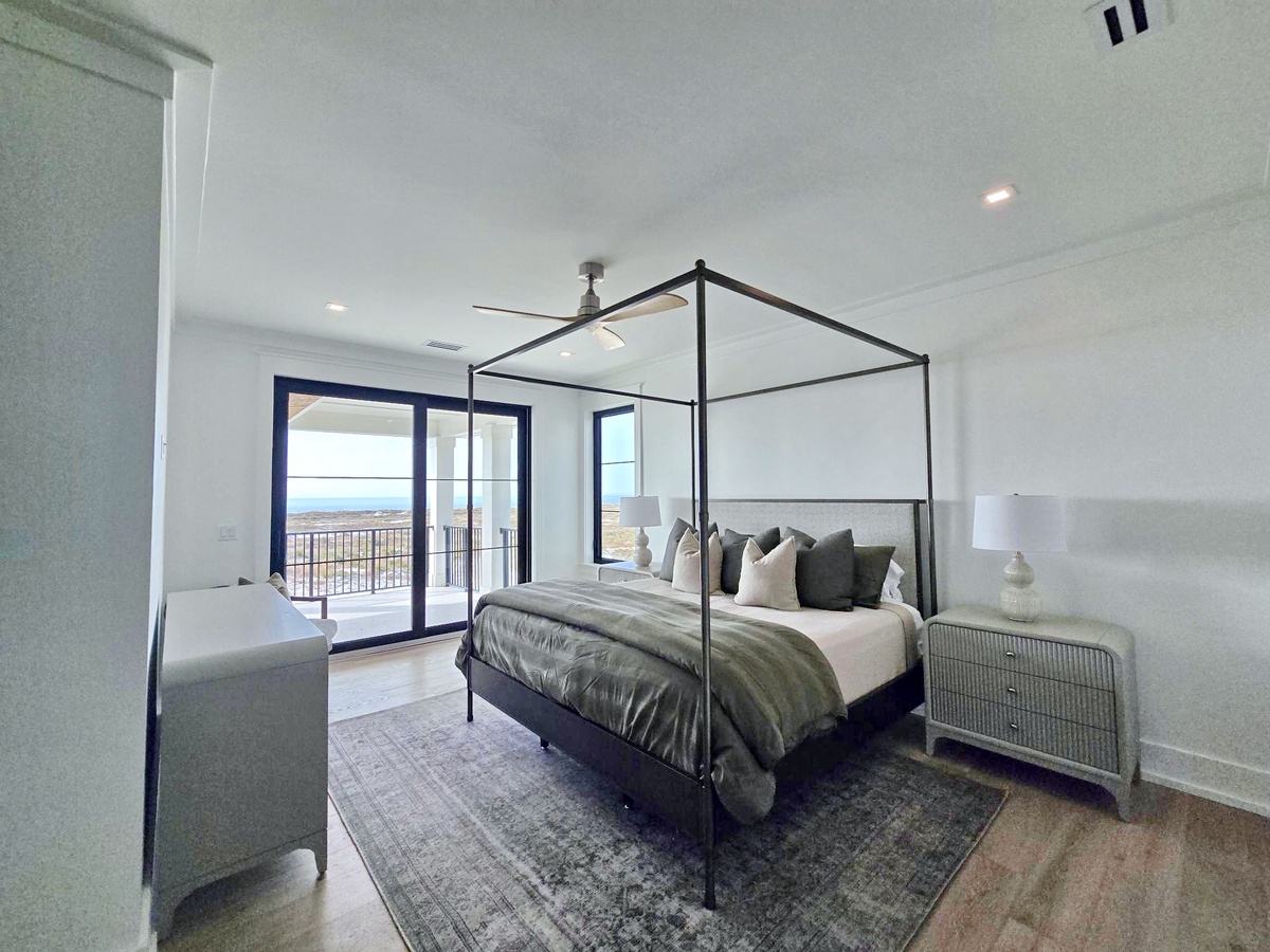 Unwind in your serene canopy bed with stunning views through floor-to-ceiling windows, where natural light fills the sophisticated space.