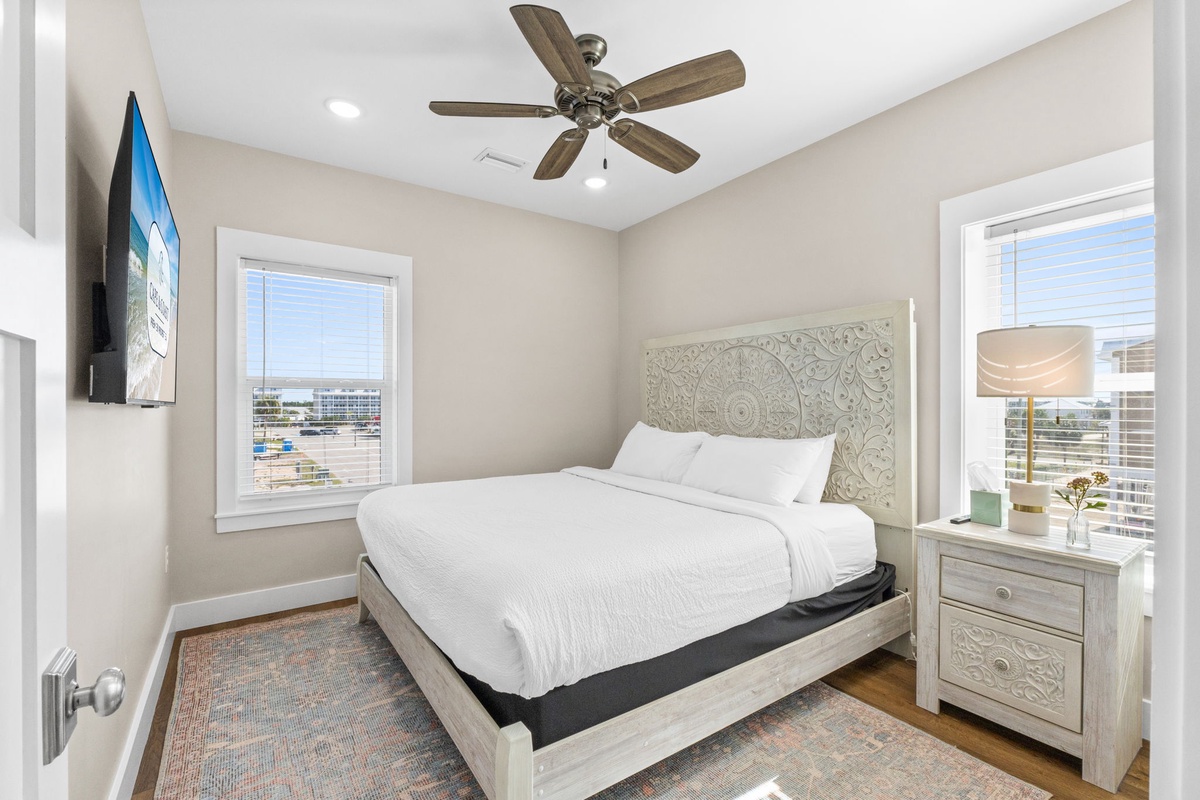 Your peaceful bedroom retreat features crisp linens, a decorative headboard, and natural light streaming through windows overlooking the vibrant cityscape.