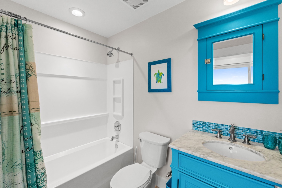 Refresh in your bright bathroom featuring vibrant turquoise accents, marble counters, and cheerful sea-themed touches that make daily routines feel like vacation.