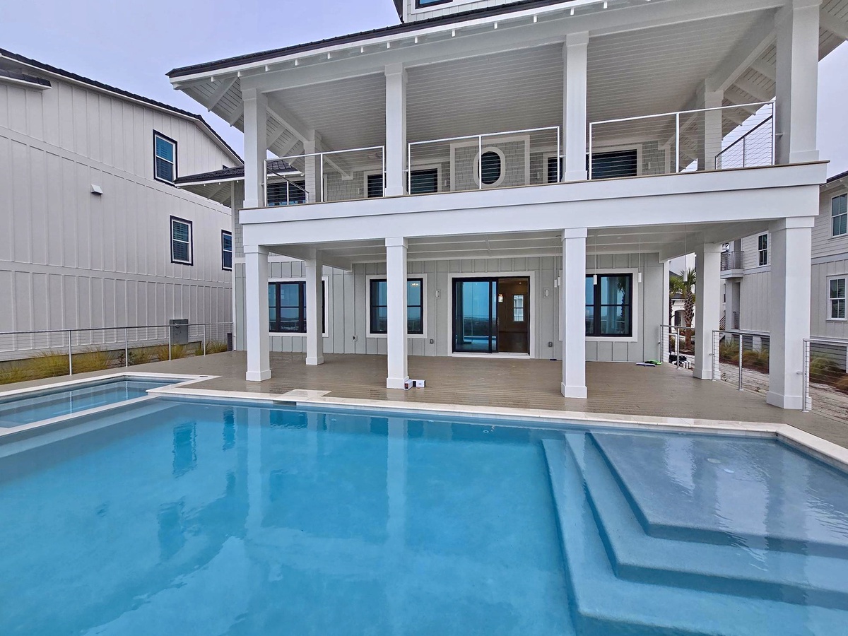 Modern coastal retreat featuring a private swimming pool with spa area and expansive covered outdoor living spaces.