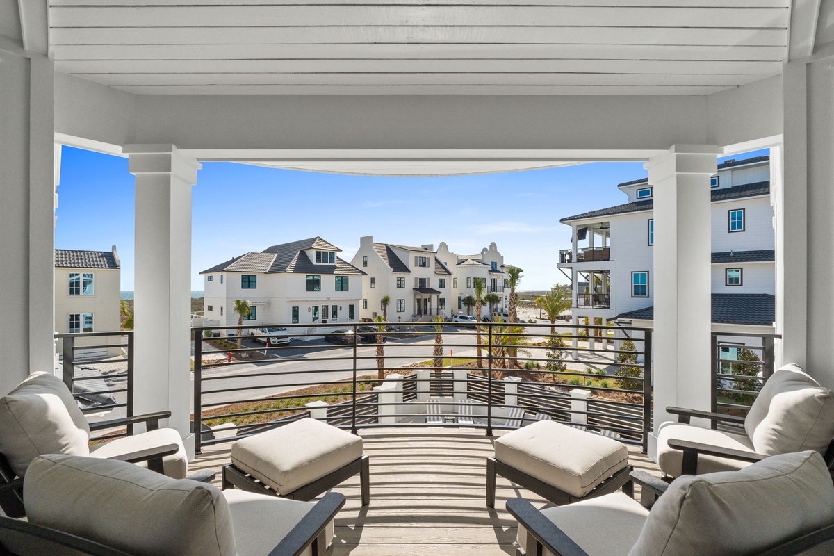 Relax in your private balcony seating area with comfortable cushioned chairs and panoramic views of the charming neighborhood below.
