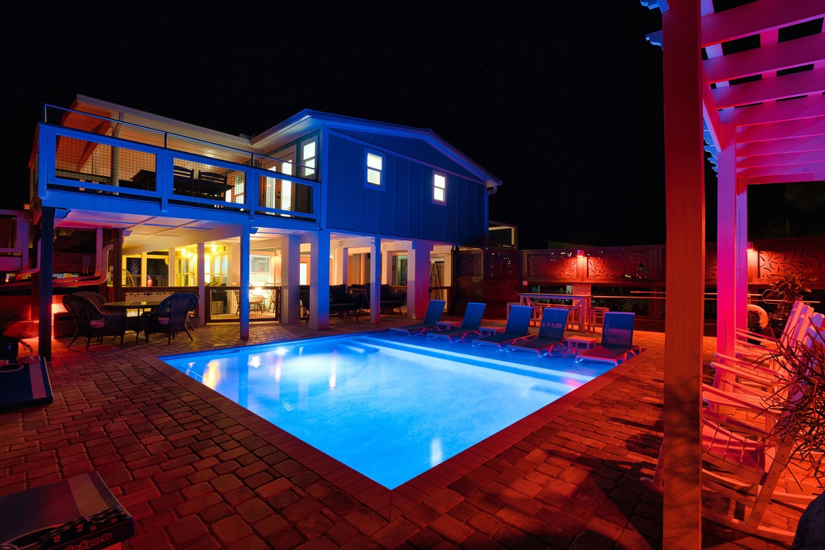 Stunning vacation rental with illuminated pool and modern architecture creates the perfect nighttime retreat atmosphere.