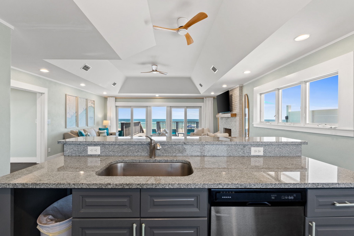 Step into your open-concept haven where the kitchen flows seamlessly into a bright living area framed by stunning ocean views—perfect for gathering with loved ones while the sea beckons just beyond.