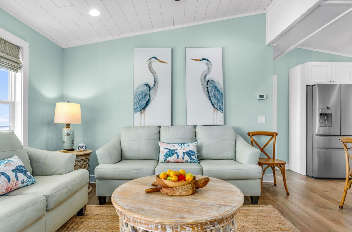 Sink into soft coastal comfort in this bright living room, where sea-inspired artwork and gentle mint walls create your perfect retreat.