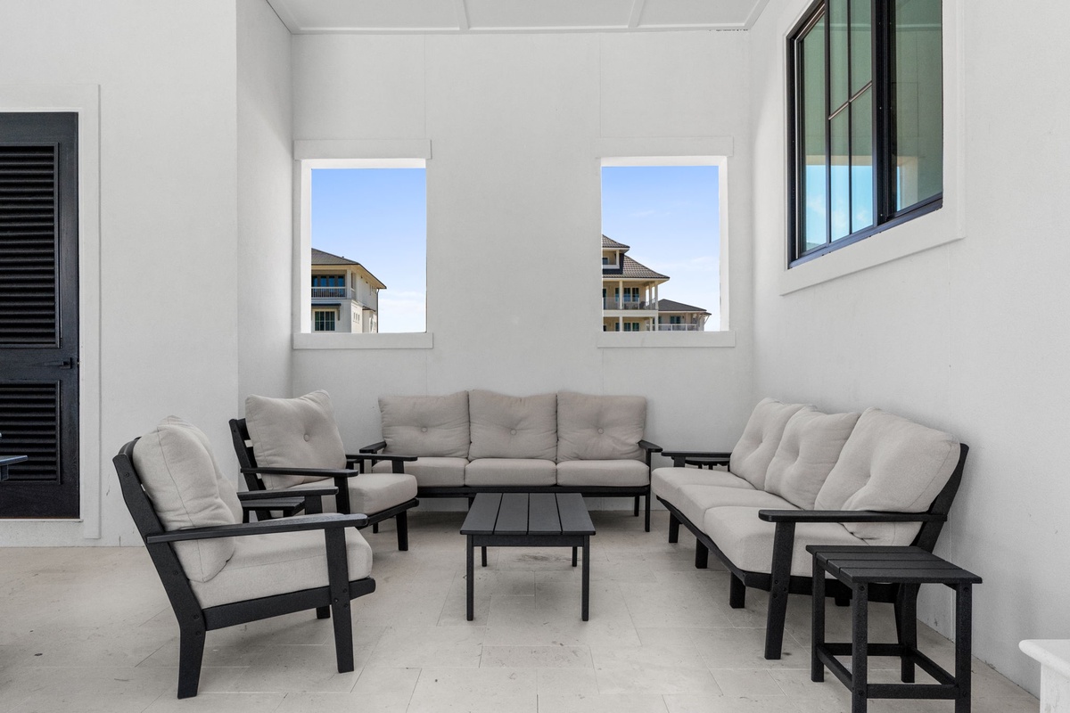 Unwind in your private screened patio with plush seating for eight, perfect for morning coffee or evening conversations beneath the coastal breeze.