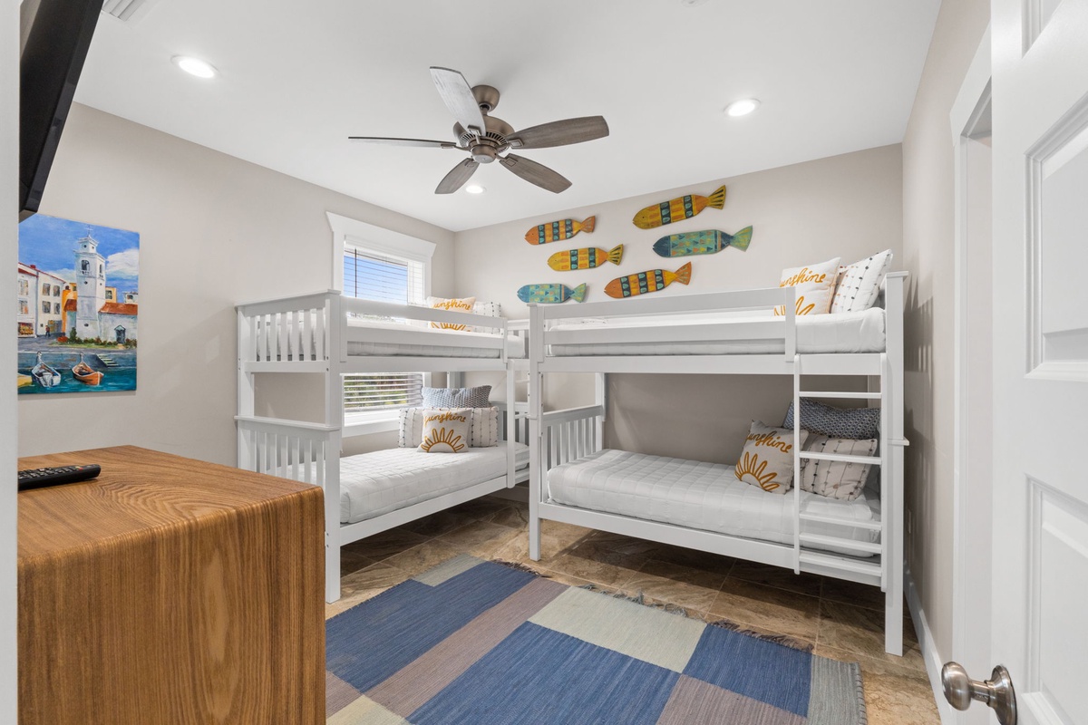 Bright coastal-themed bunk room where kids can share seaside adventures. Colorful fish art and soft lighting create a playful, beach-house vibe.
