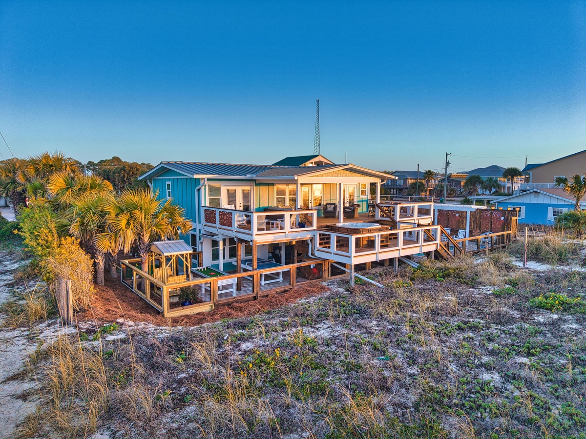 Stunning beachfront property with expansive wraparound decks and tropical landscaping in a peaceful coastal neighborhood.