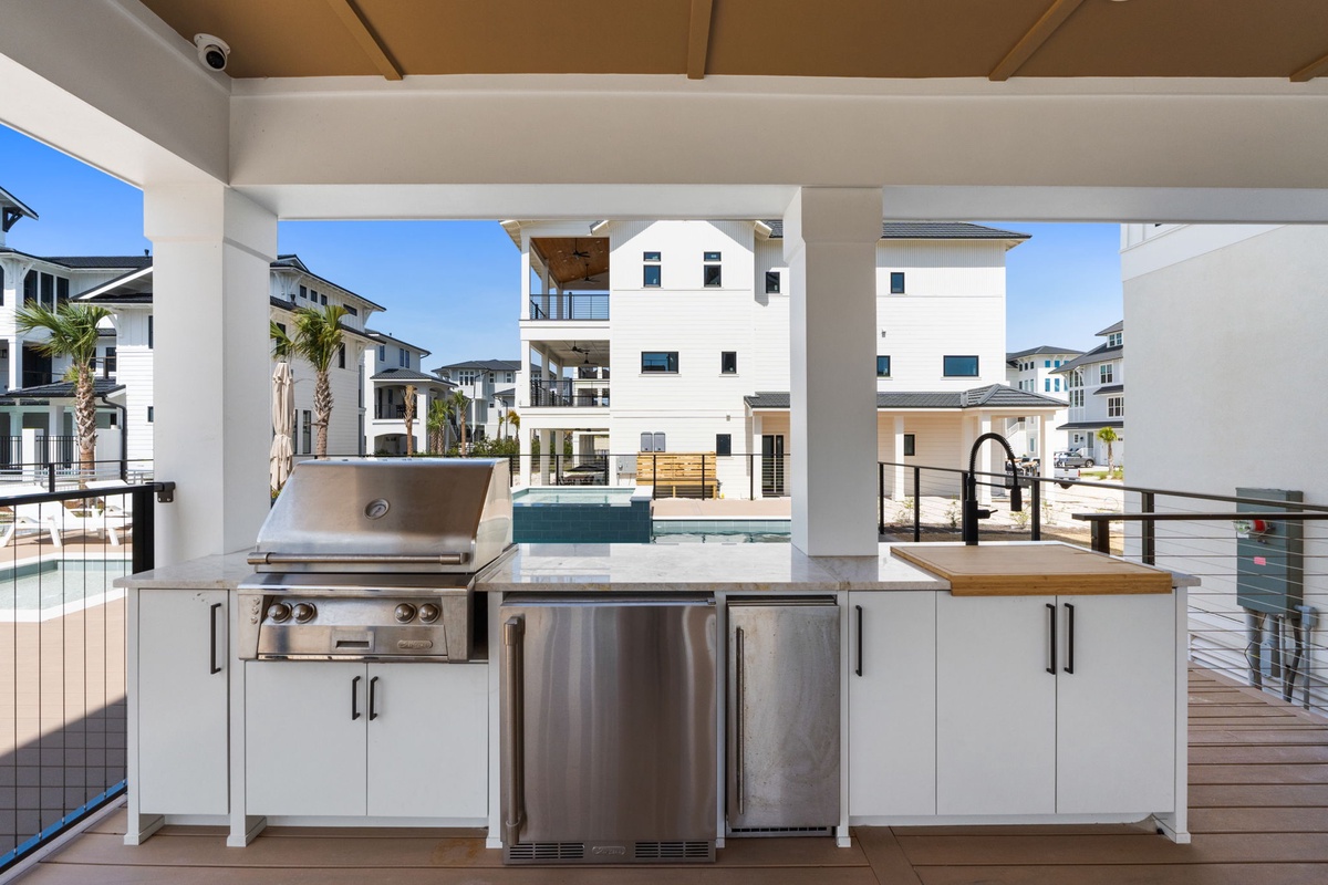 Prepare your favorite meals in this stunning outdoor kitchen with professional-grade appliances and panoramic community views.