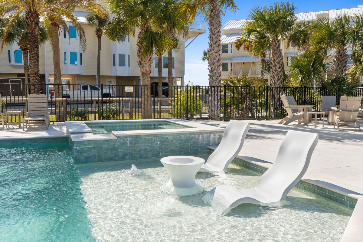 Slip into this stunning pool area with built-in loungers and tropical palms creating your perfect coastal retreat.