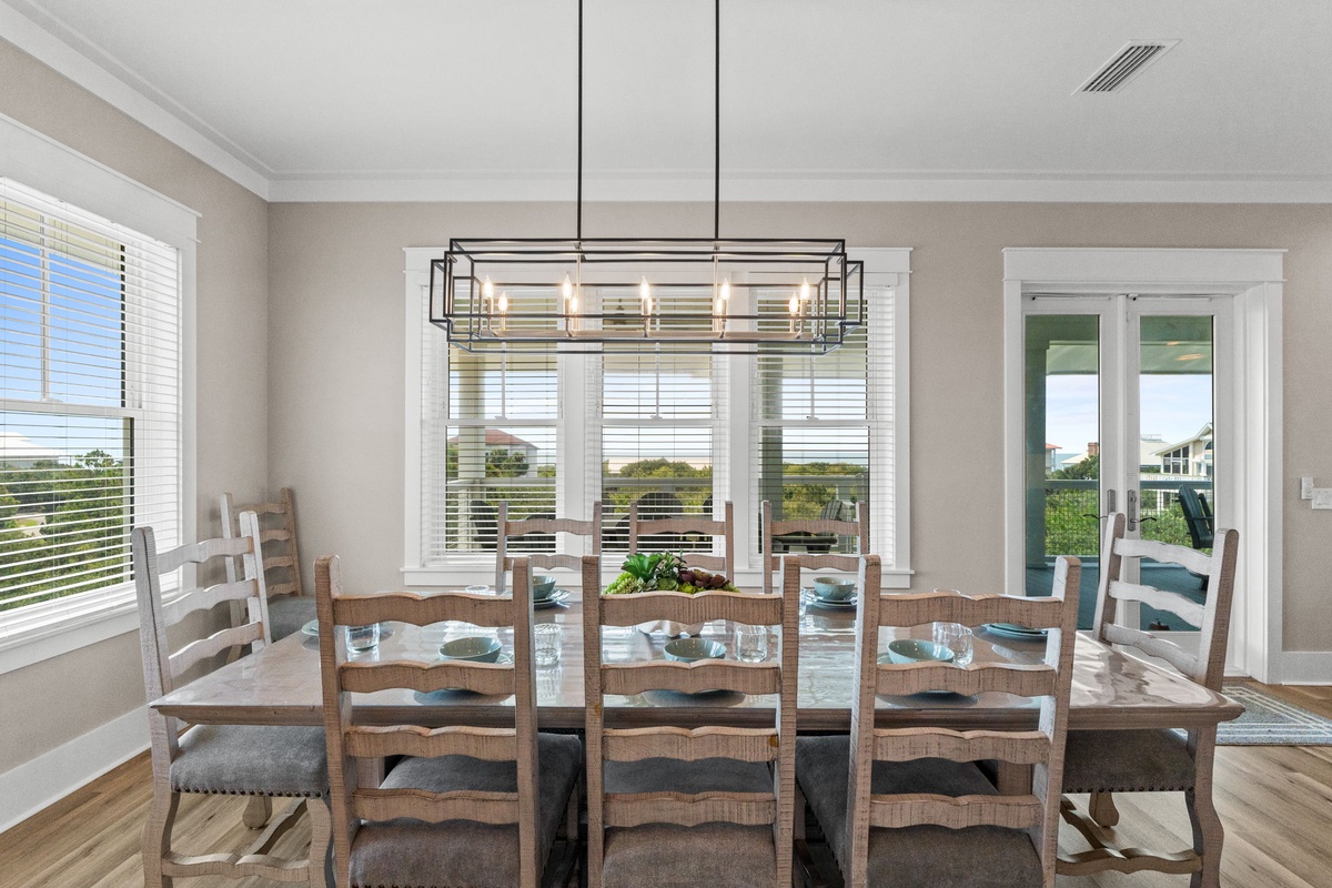Gather around a beautiful wooden dining table where sunlight pours through multiple windows, creating the perfect setting for your morning coffee or shared meals with loved ones.