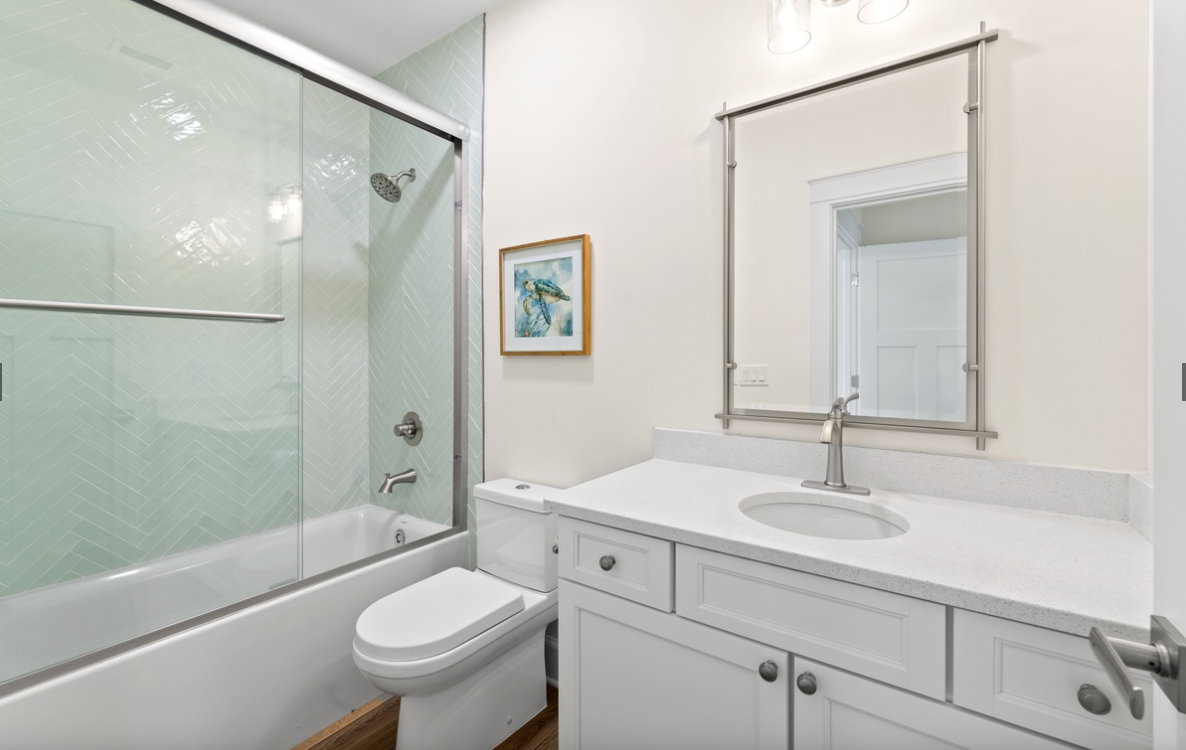 Step into your beautifully designed bathroom with gleaming quartz counters, spacious shower, and serene coastal artwork creating your private spa retreat.