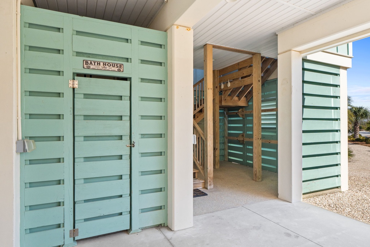 Charming mint-green doors lead to your private bath house, creating a unique coastal retreat experience.