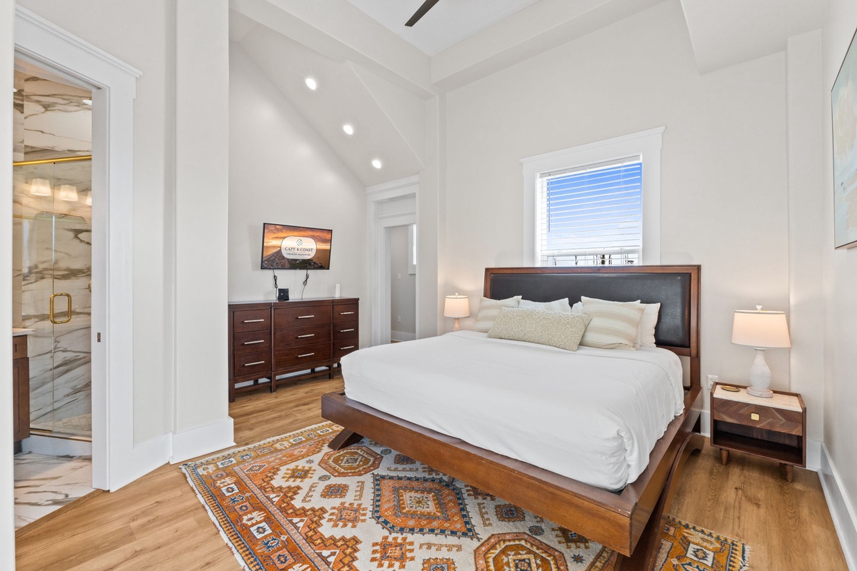 Sleep peacefully in this elegant bedroom with warm hardwood floors, soft linens, and ambient lighting for your perfect retreat.