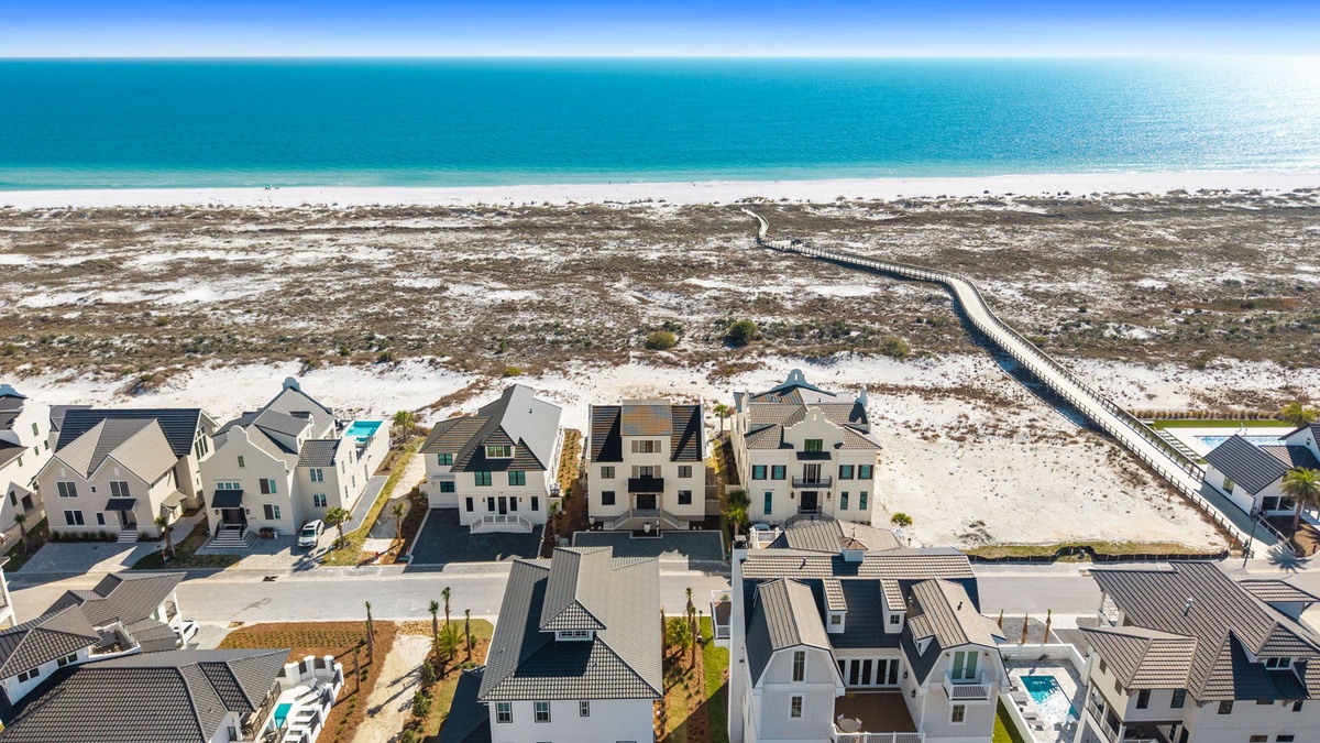 Stunning beachfront community with pristine white sand and turquoise waters just steps away from modern coastal homes.