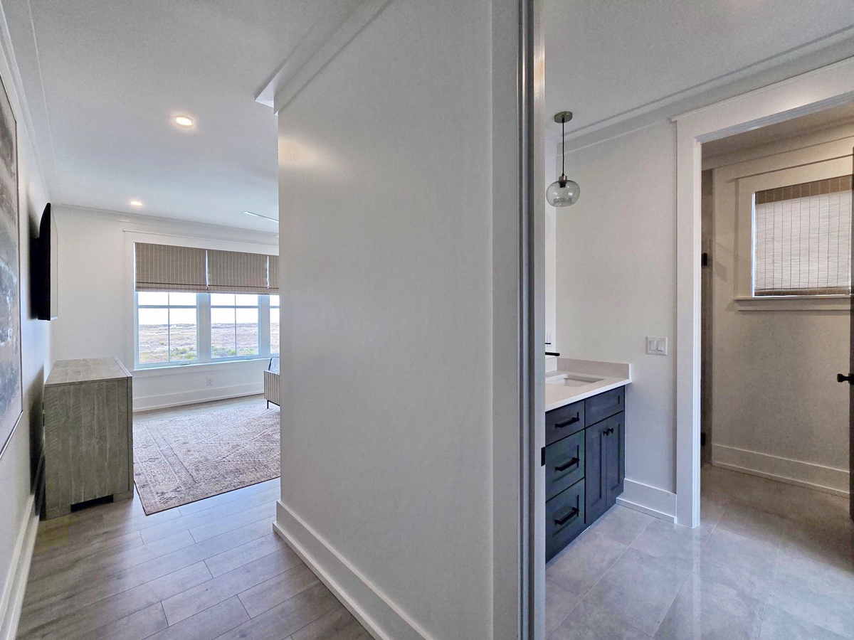 Step into your bright bedroom suite where natural light fills the space through bamboo blinds and panoramic windows frame city views.