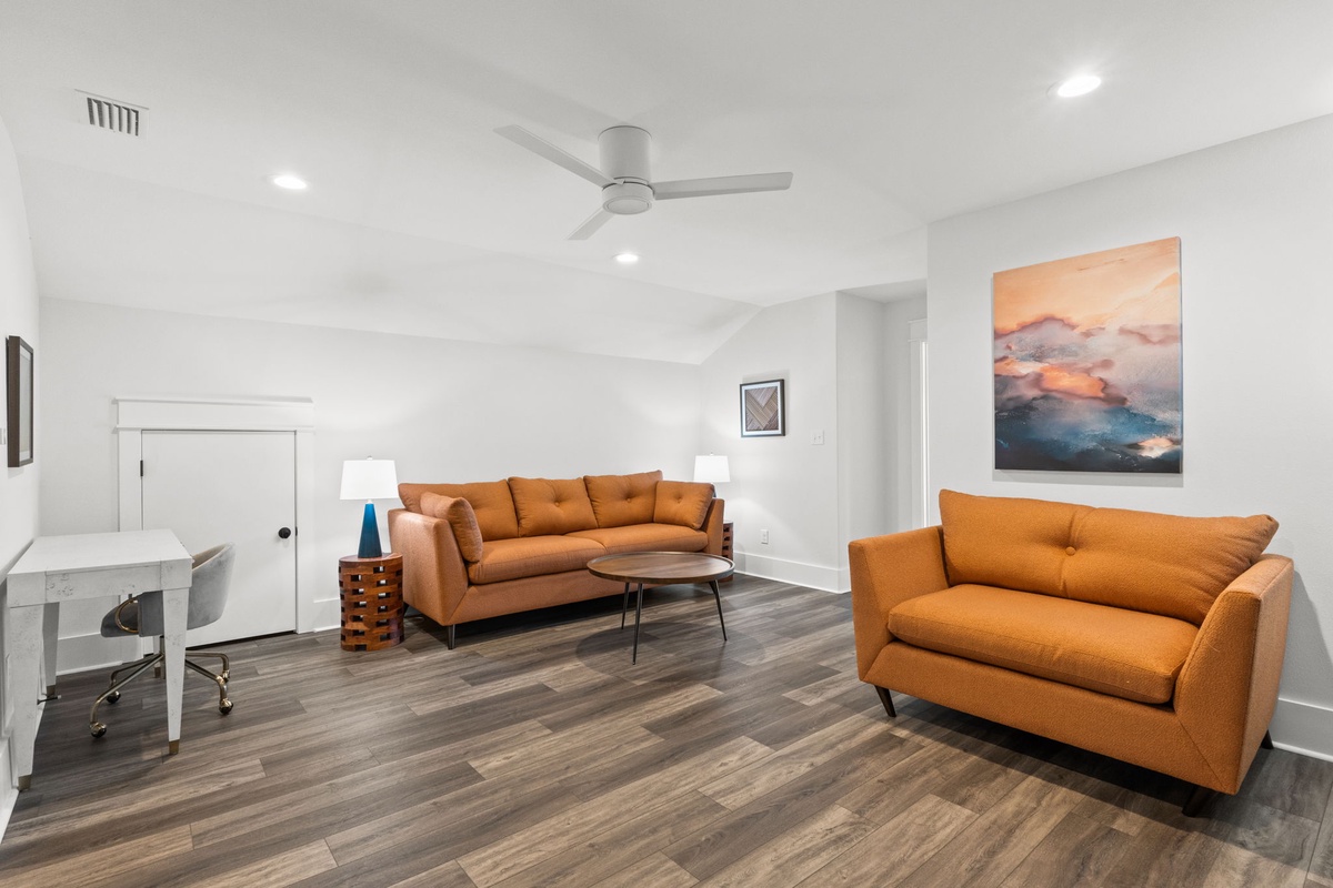 Unwind in your bright, modern living room with plush seating, stylish artwork, and a ceiling fan to keep you comfortable year-round.