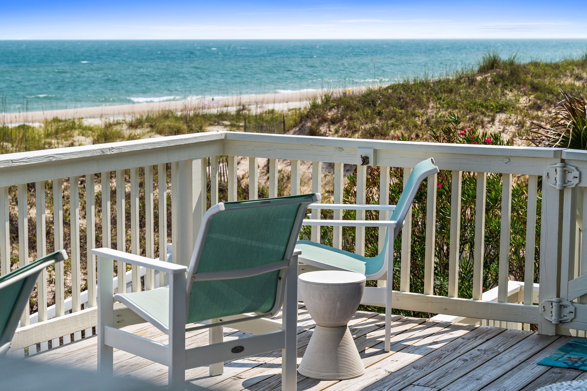 Wake up to this stunning beachfront view where your private deck overlooks soft sands and sparkling turquoise waves. Sip your morning coffee here and feel the ocean breeze as seabirds glide by.