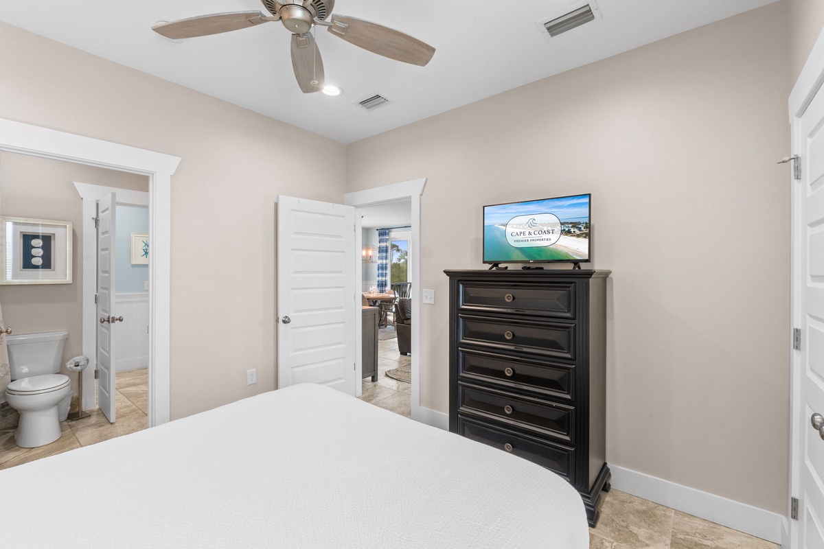 Your coastal retreat bedroom offers plenty of drawer space with a stylish dresser, ceiling fan for comfort, and smart TV for entertainment. An ensuite bathroom awaits just steps from your bed.