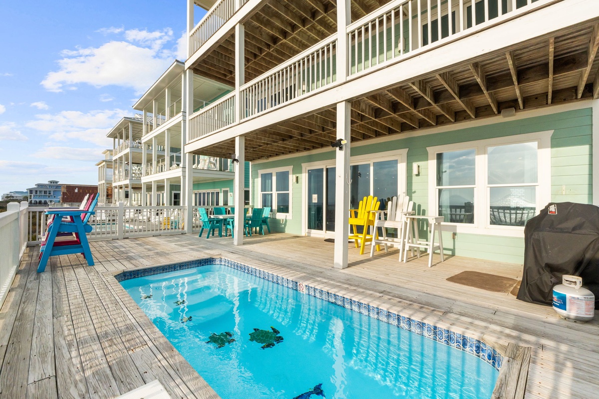 Your private pool deck awaits with colorful chairs and BBQ, perfect for sunny days by the water.
