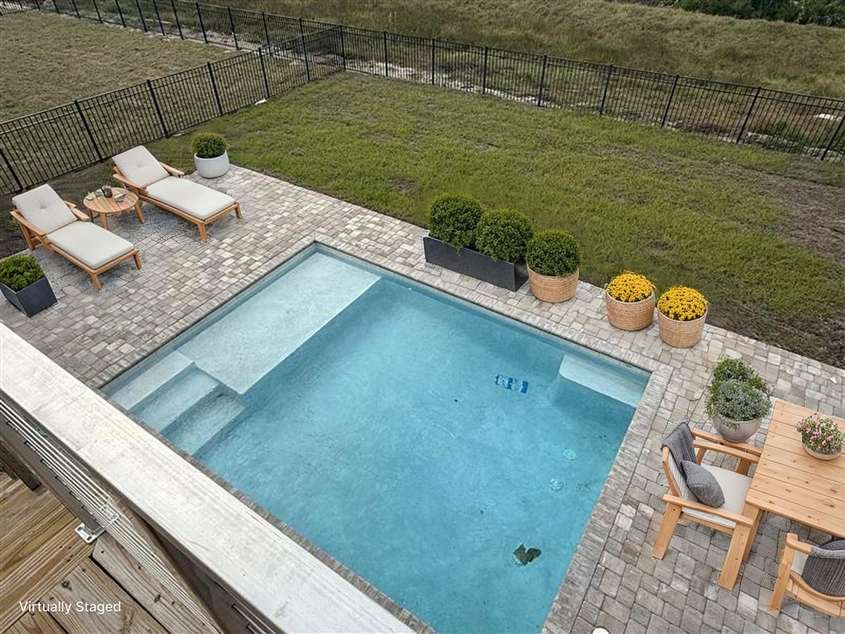 Overhead view of the private pool area surrounded by elegant paver patio and landscaped grounds.