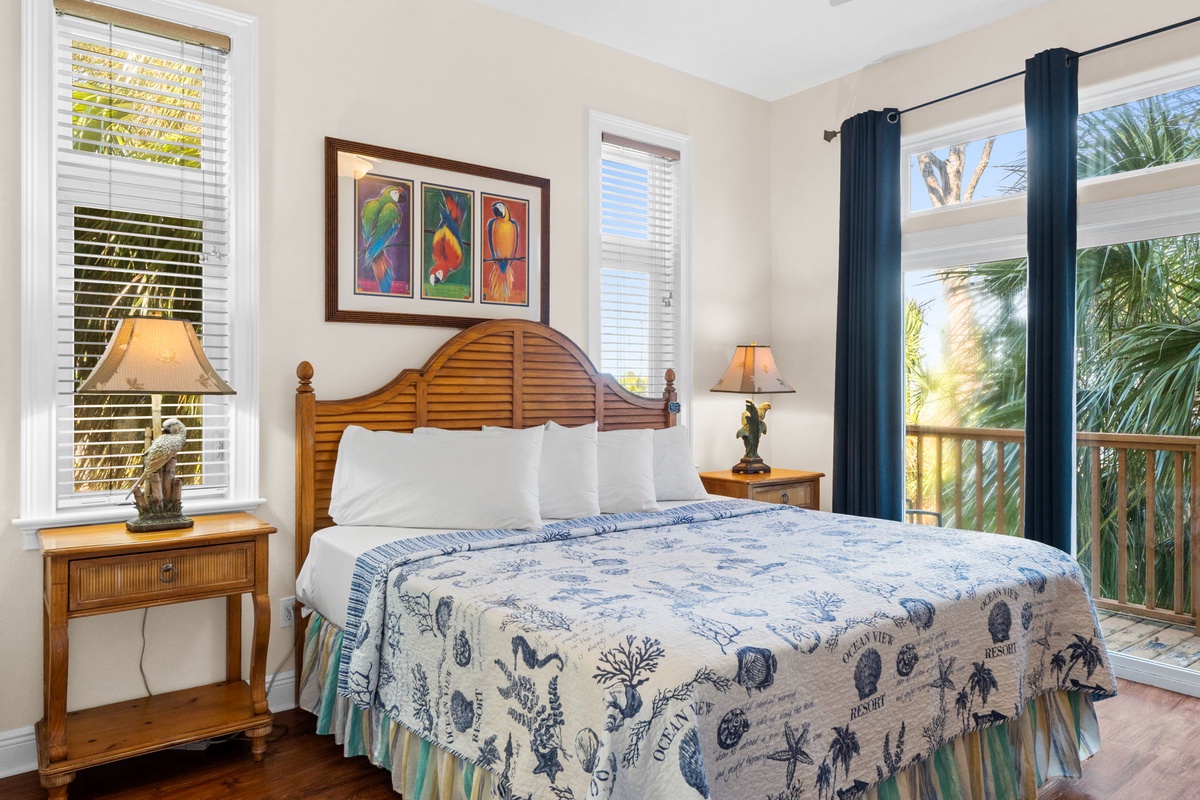 Wake up in your tropical-themed bedroom with wooden furnishings and bright artwork, surrounded by palm trees visible through your private balcony doors.