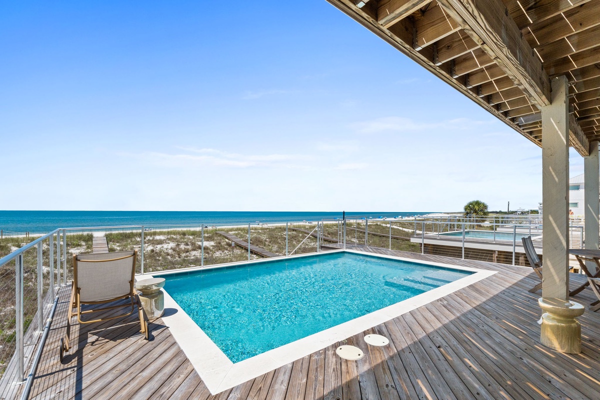 Beachfront paradise awaits with a sparkling private pool and stunning ocean views framing endless white sands, just steps from the sea.