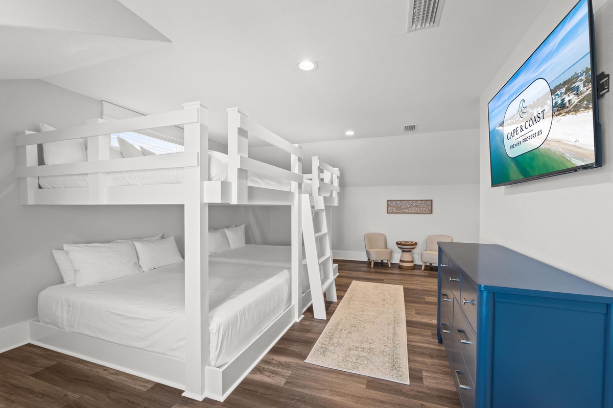 Your group will love these sturdy white bunk beds, offering comfortable sleeping space for everyone. Cozy linens, a coastal vibe, and a wall-mounted TV ensure relaxation after beach days.