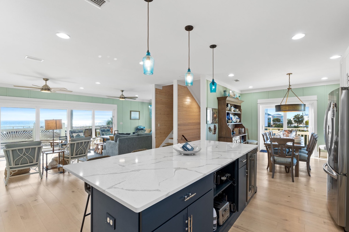 Your open-concept kitchen flows seamlessly into the living area, where marble countertops and ocean views create the perfect backdrop for memorable meals.