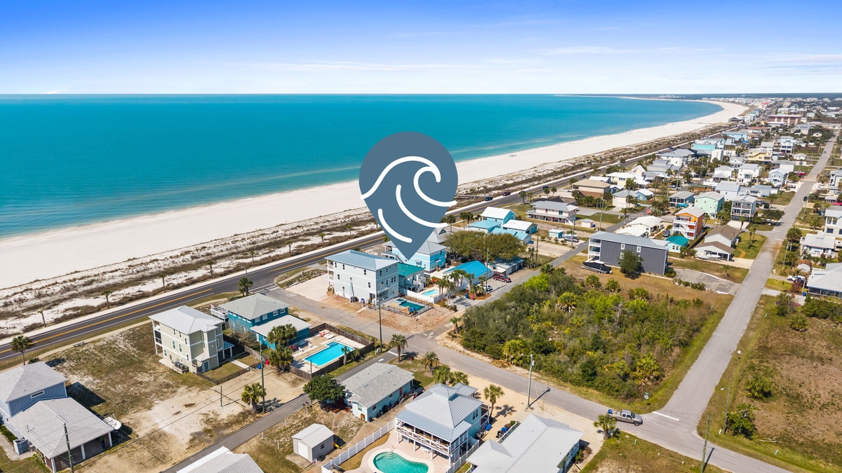 Aerial view of beachfront vacation rental community with stunning turquoise waters and pristine white sand coastline.