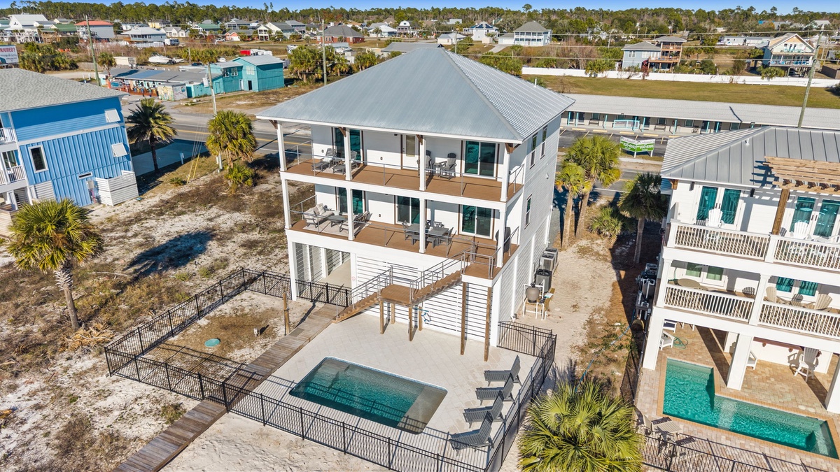 Modern coastal rental with private pool and elevated decks in beachside community.