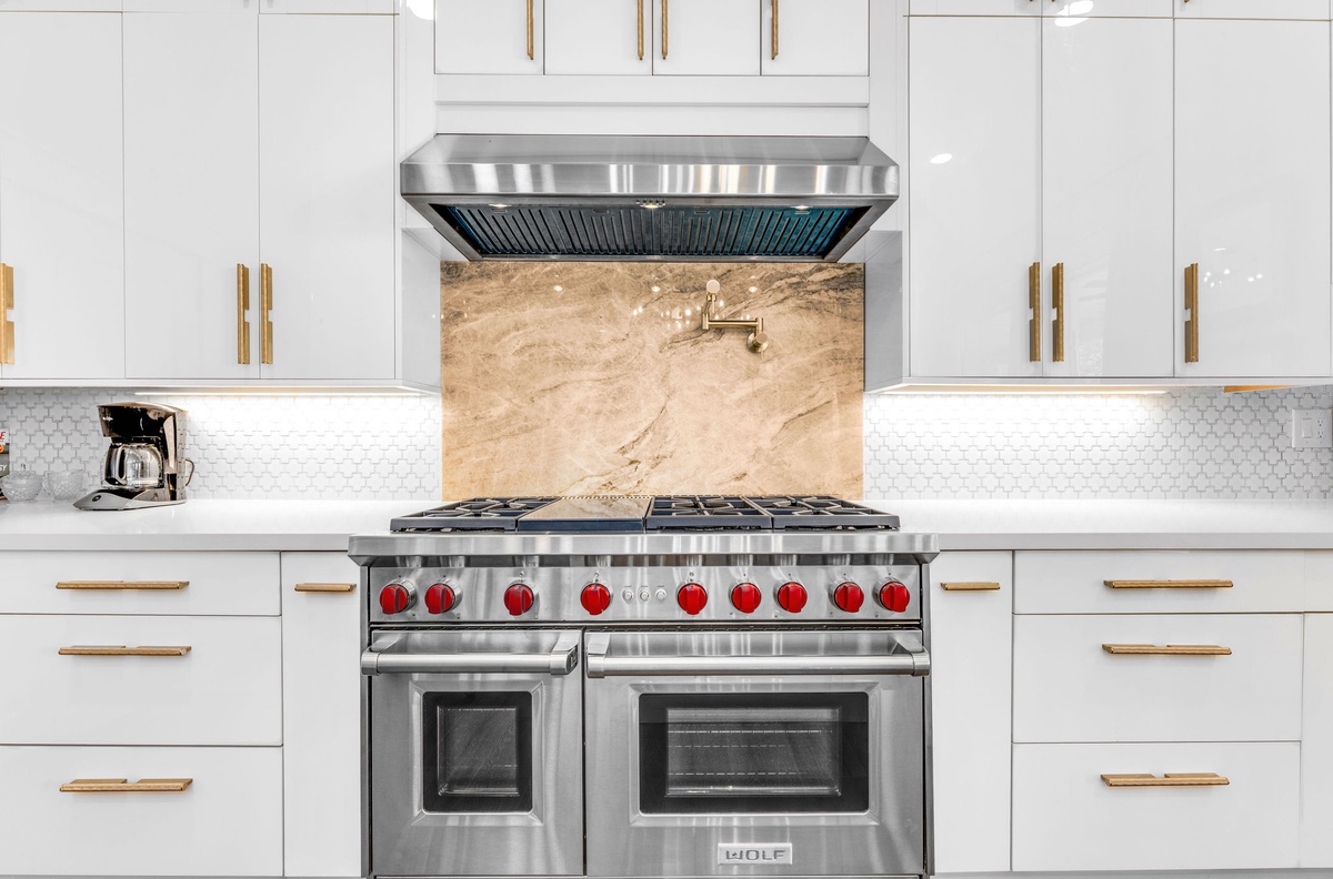 Cook gourmet meals with this professional-grade range and spacious countertops in your pristine white kitchen.
