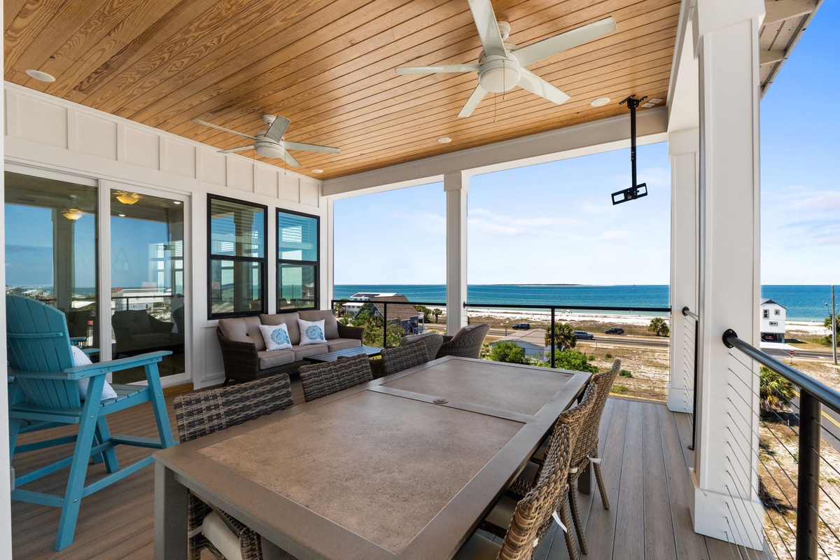 Unwind on your private covered terrace with stunning ocean views, comfortable seating, and dining space perfect for morning coffee or sunset meals.