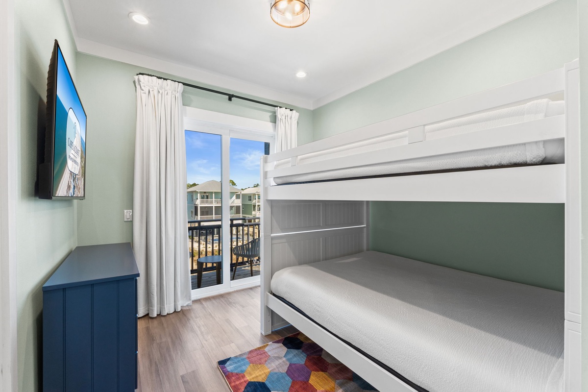 Your family will love this bright bunk room with its coastal colors, TV entertainment, and private balcony access for morning sunshine.