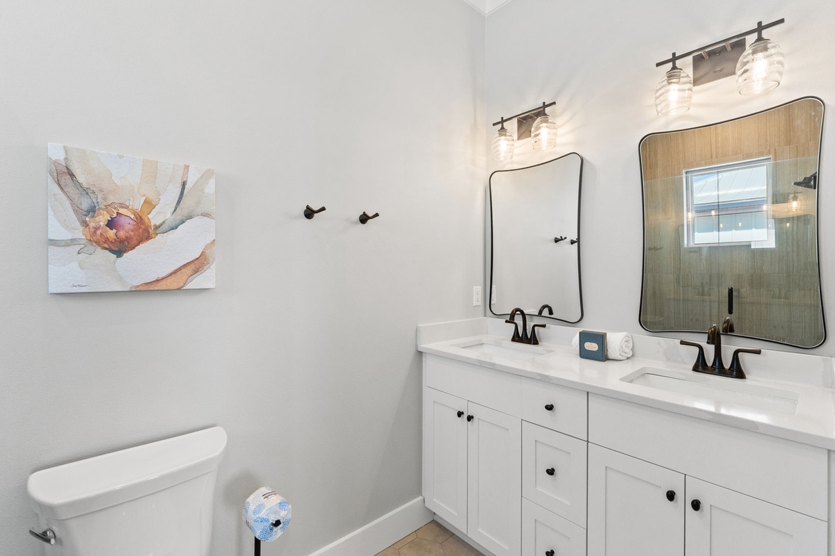 Your bright bathroom features dual sinks, elegant mirrors, and warm lighting—perfect for getting ready together in comfort.