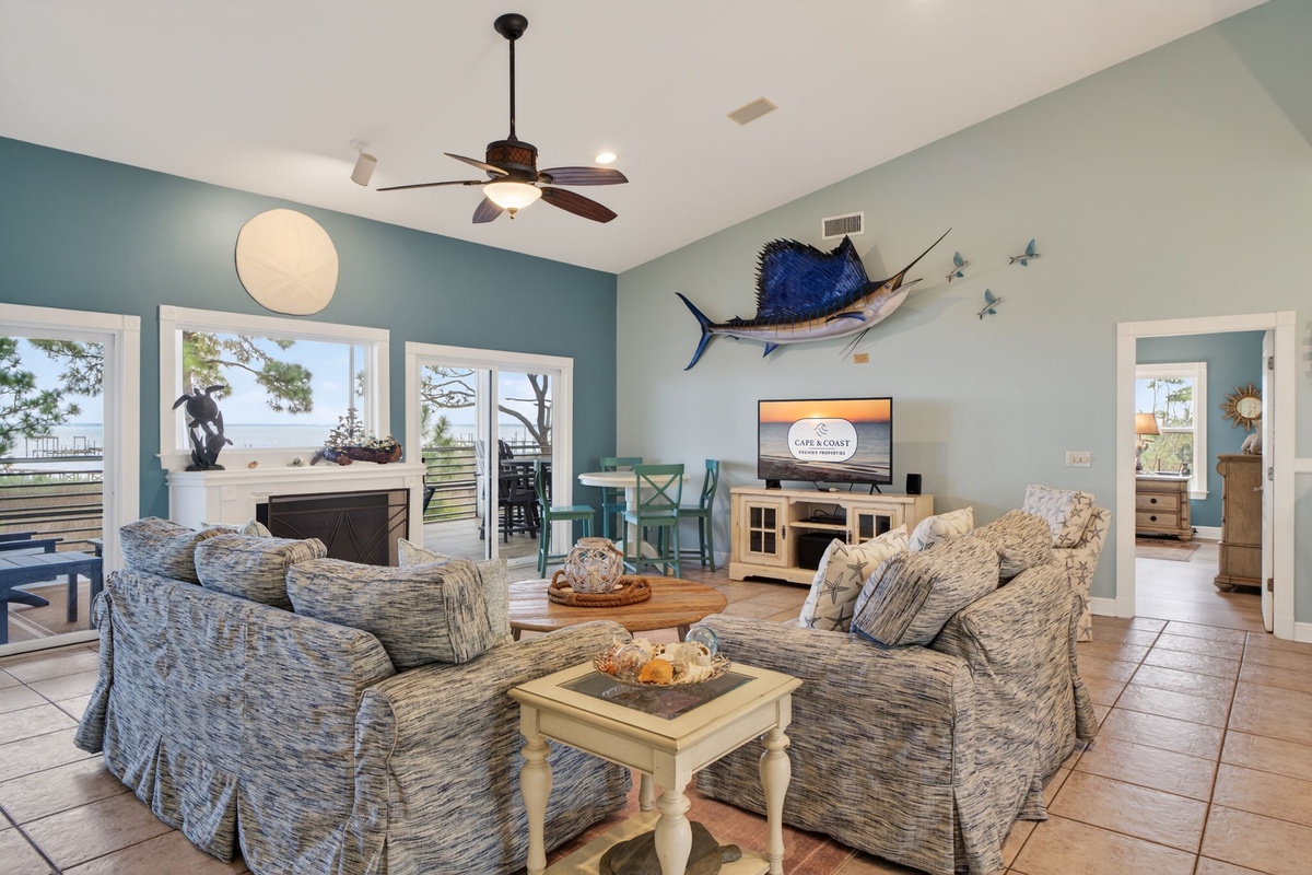 Unwind in your coastal living room where ocean breezes flow through, sailfish art inspires adventure, and sunset views await beyond.